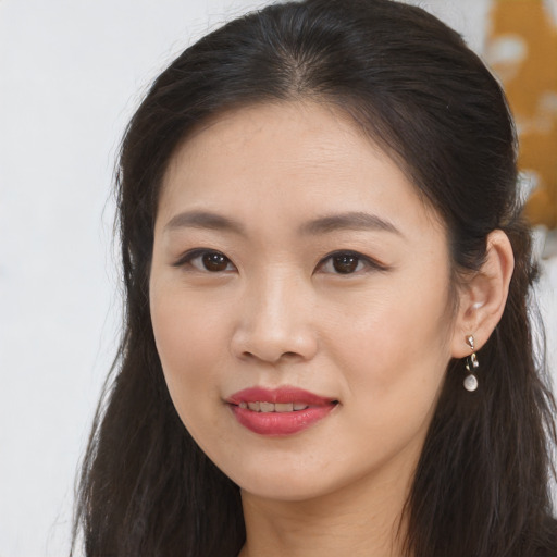 Joyful asian young-adult female with long  brown hair and brown eyes