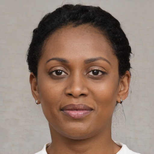 Joyful black young-adult female with short  black hair and brown eyes