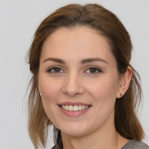 Joyful white young-adult female with medium  brown hair and brown eyes