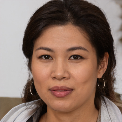 Joyful asian young-adult female with medium  brown hair and brown eyes