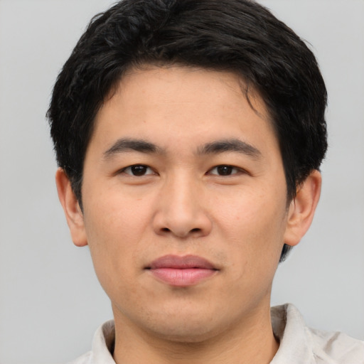 Joyful asian young-adult male with short  black hair and brown eyes