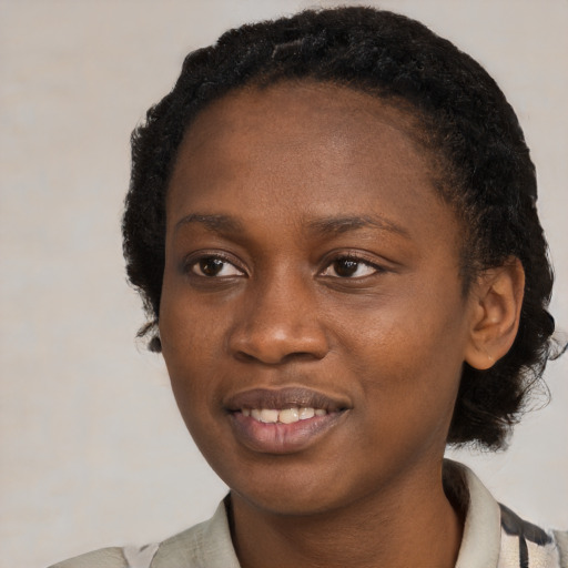 Joyful black young-adult female with medium  black hair and brown eyes
