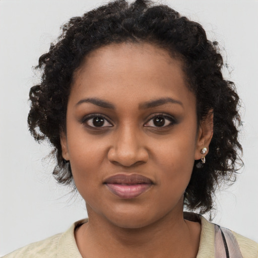 Joyful black young-adult female with long  black hair and brown eyes