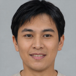 Joyful asian young-adult male with short  black hair and brown eyes