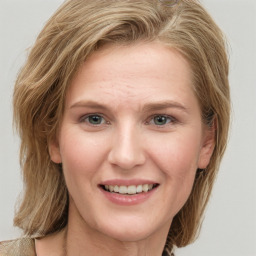 Joyful white young-adult female with long  brown hair and blue eyes