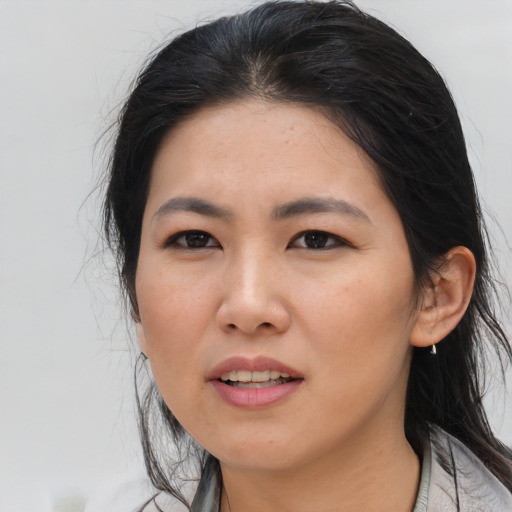 Joyful asian adult female with medium  brown hair and brown eyes