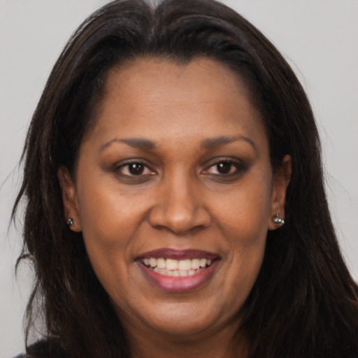 Joyful black adult female with long  brown hair and brown eyes