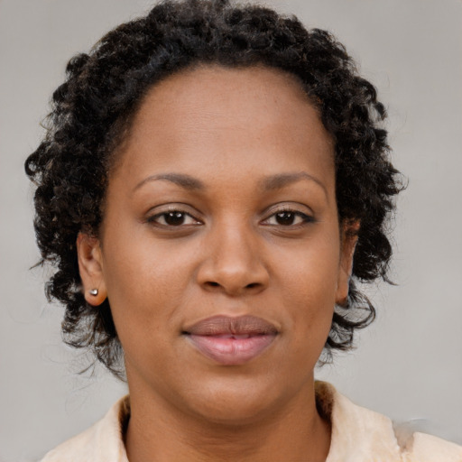Joyful black adult female with medium  brown hair and brown eyes