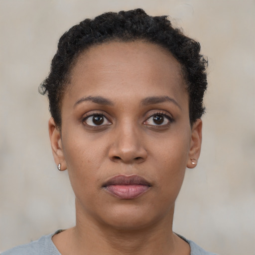 Joyful black young-adult female with short  brown hair and brown eyes