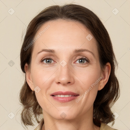 Joyful white adult female with medium  brown hair and grey eyes