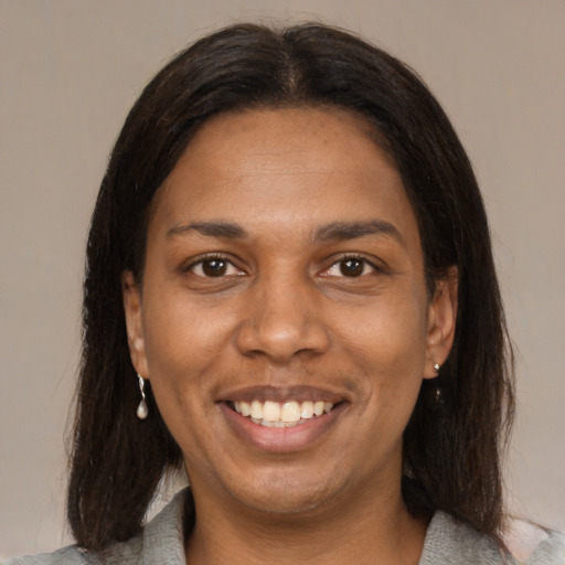 Joyful black young-adult female with medium  brown hair and brown eyes