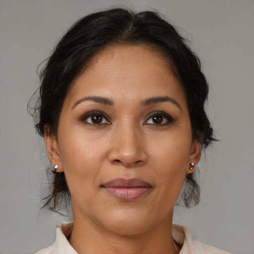 Joyful latino adult female with medium  brown hair and brown eyes