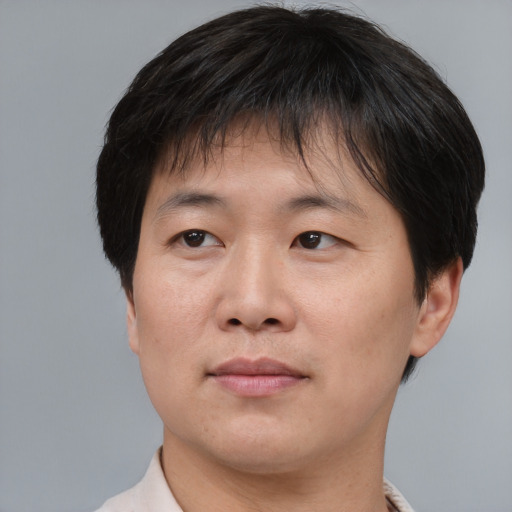 Joyful asian adult male with short  brown hair and brown eyes