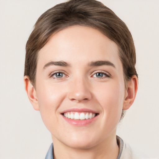 Joyful white young-adult female with short  brown hair and grey eyes