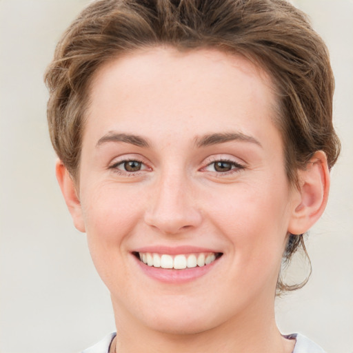 Joyful white young-adult female with short  brown hair and green eyes