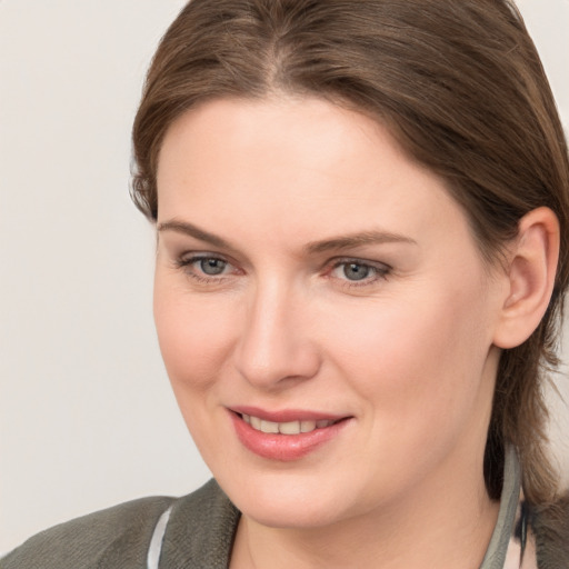 Joyful white young-adult female with medium  brown hair and grey eyes