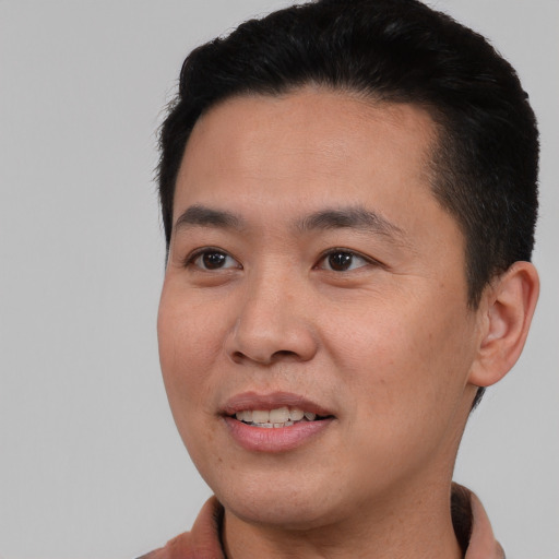 Joyful asian young-adult male with short  black hair and brown eyes