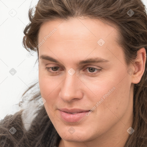 Joyful white young-adult male with long  brown hair and brown eyes