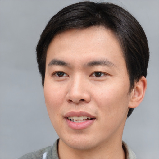 Joyful asian young-adult male with short  brown hair and brown eyes