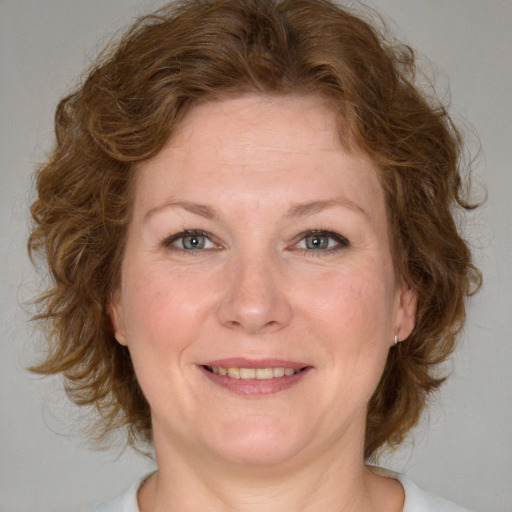 Joyful white adult female with medium  brown hair and blue eyes