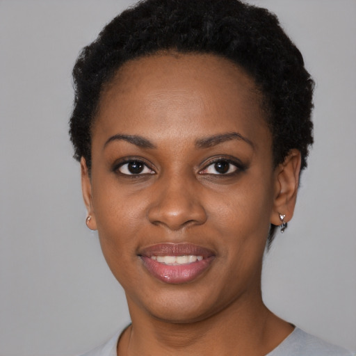 Joyful black young-adult female with short  black hair and brown eyes
