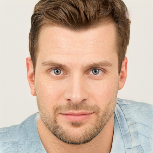 Joyful white young-adult male with short  brown hair and blue eyes