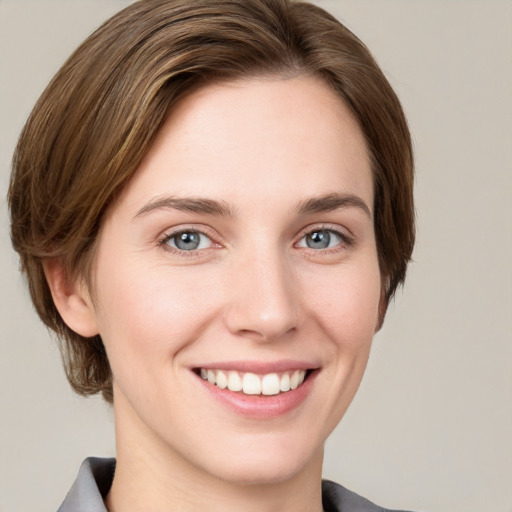 Joyful white young-adult female with medium  brown hair and grey eyes