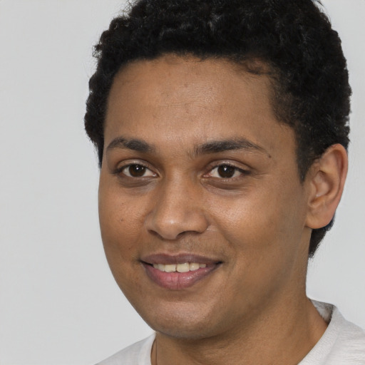 Joyful black young-adult male with short  brown hair and brown eyes