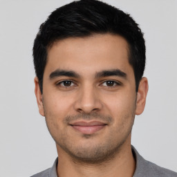 Joyful latino young-adult male with short  black hair and brown eyes