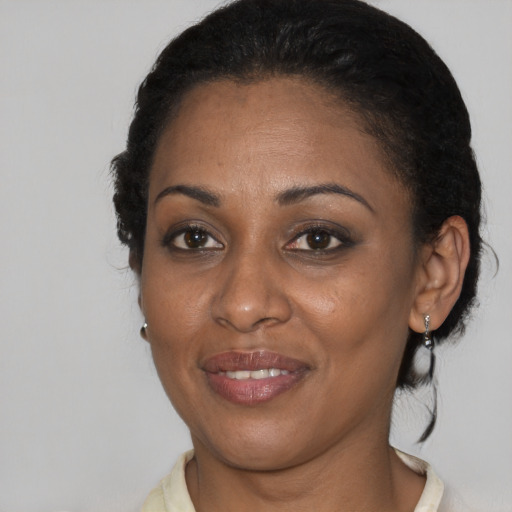 Joyful black young-adult female with short  black hair and brown eyes