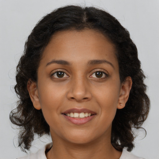 Joyful latino young-adult female with medium  brown hair and brown eyes