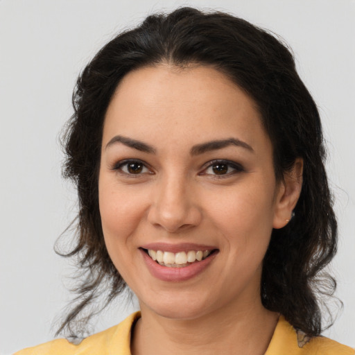 Joyful latino young-adult female with medium  brown hair and brown eyes