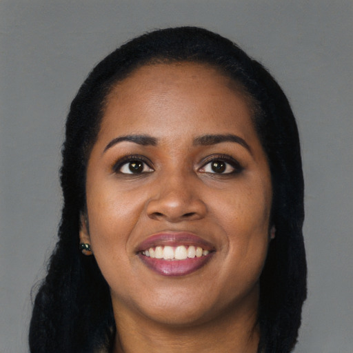 Joyful black young-adult female with long  black hair and brown eyes