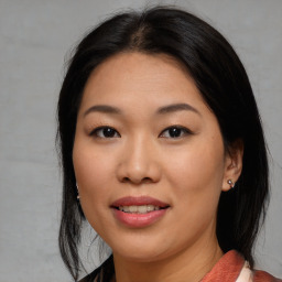 Joyful asian young-adult female with medium  brown hair and brown eyes