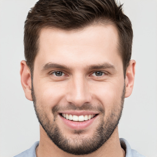 Joyful white young-adult male with short  brown hair and brown eyes