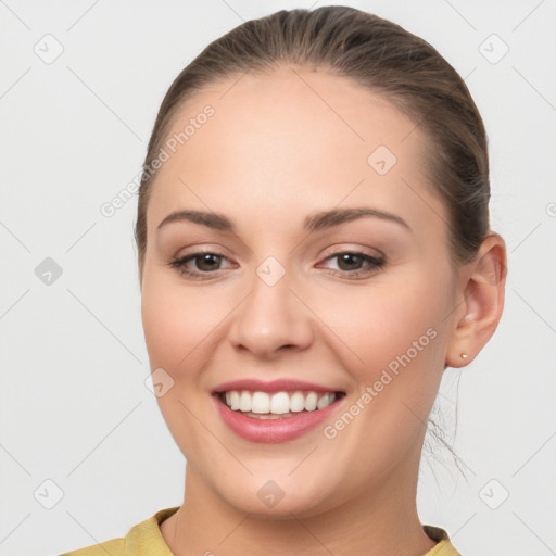 Joyful white young-adult female with long  brown hair and brown eyes