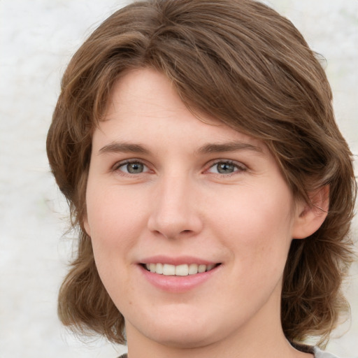 Joyful white young-adult female with medium  brown hair and green eyes