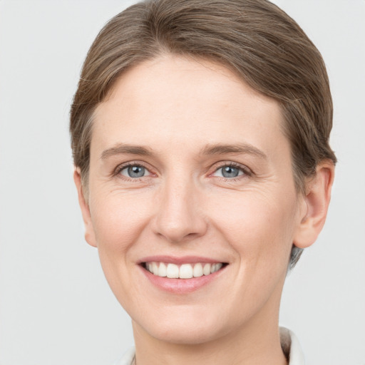 Joyful white young-adult female with short  brown hair and grey eyes