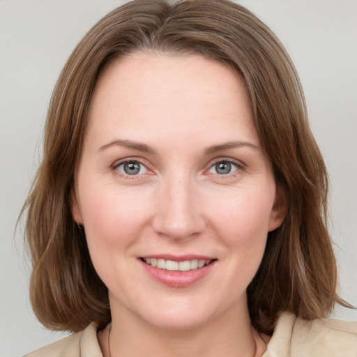 Joyful white young-adult female with medium  brown hair and grey eyes