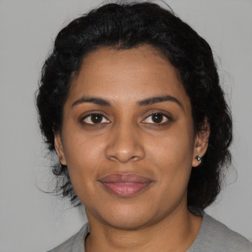 Joyful black young-adult female with medium  black hair and brown eyes