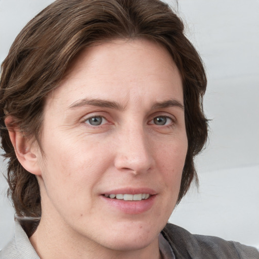 Joyful white adult female with medium  brown hair and blue eyes