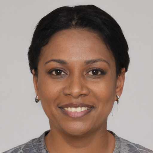 Joyful black young-adult female with short  black hair and brown eyes