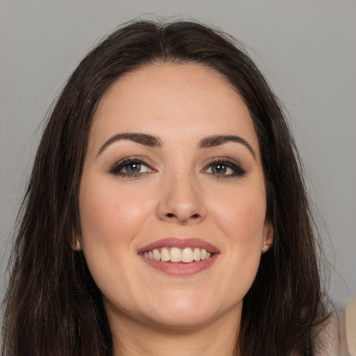 Joyful white young-adult female with long  brown hair and brown eyes