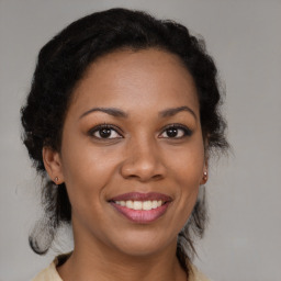 Joyful black adult female with medium  brown hair and brown eyes