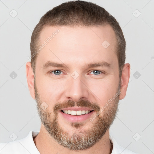 Joyful white young-adult male with short  brown hair and grey eyes