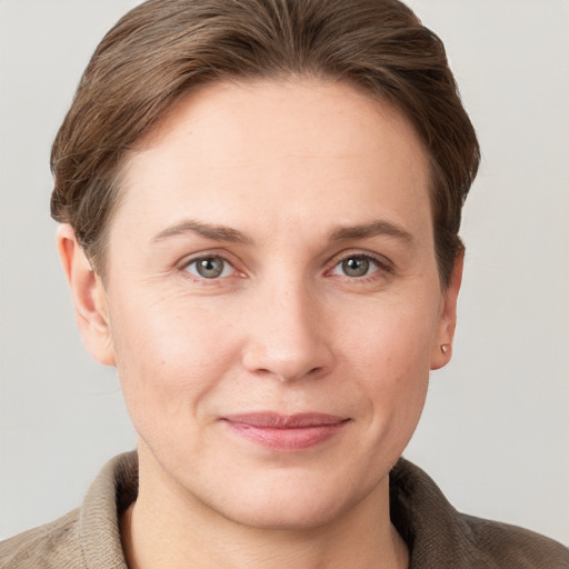 Joyful white young-adult female with short  brown hair and grey eyes