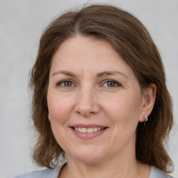 Joyful white adult female with medium  brown hair and grey eyes