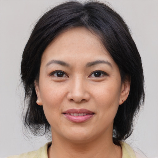 Joyful asian adult female with medium  brown hair and brown eyes