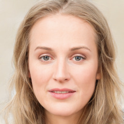 Joyful white young-adult female with long  brown hair and blue eyes