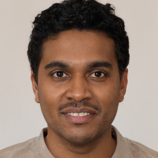 Joyful black young-adult male with short  black hair and brown eyes